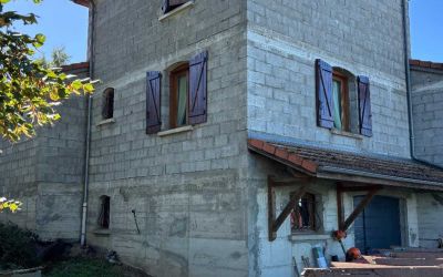 Chantier d'isolation par l'extérieur Ecothermic : une maison entièrement transformée avec une façade au design contemporain.  Finition Uniso bois, coloris marbre rouge.