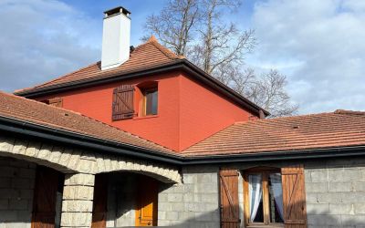 Chantier d'isolation par l'extérieur Ecothermic : une maison entièrement transformée avec une façade au design contemporain.  Finition Uniso bois, coloris marbre rouge.