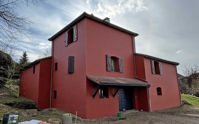 Chantier d'isolation par l'extérieur Ecothermic : une maison entièrement transformée avec une façade au design contemporain.  Finition Uniso bois, coloris marbre rouge.