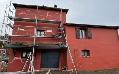 Chantier d'isolation par l'extérieur Ecothermic : une maison entièrement transformée avec une façade au design contemporain.  Finition Uniso bois, coloris marbre rouge.