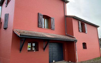 Chantier d'isolation par l'extérieur Ecothermic : une maison entièrement transformée avec une façade au design contemporain.  Finition Uniso bois, coloris marbre rouge.