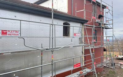 Chantier d'isolation par l'extérieur Ecothermic : une maison entièrement transformée avec une façade au design contemporain.  Finition Uniso bois, coloris marbre rouge.